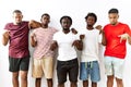 Young african group of friends standing together over isolated background pointing down looking sad and upset, indicating Royalty Free Stock Photo