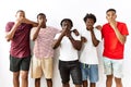 Young african group of friends standing together over isolated background shocked covering mouth with hands for mistake Royalty Free Stock Photo