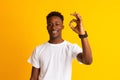 Young african guy smiling, gesturing and showing OK sign