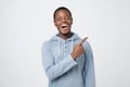 Young african guy smiling and pointing finger aside Royalty Free Stock Photo