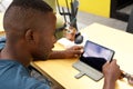 Young african guy using digital tablet at a cafe Royalty Free Stock Photo