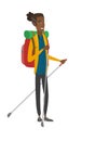 Young african hiker walking with trekking sticks.