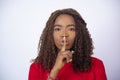 Young African lady with her finger over her mouth, gesturing for silence Royalty Free Stock Photo