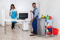 Male And Female Cleaners Cleaning Office Royalty Free Stock Photo