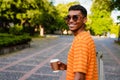 Young african man with backpack drinking coffee while standing outdoors Royalty Free Stock Photo