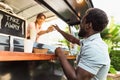 Young African man buying meal from food truck Royalty Free Stock Photo