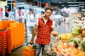 Young african man buying vegetables and fruits in grocery section at supermarket. Black man choose vegetables and fruits Royalty Free Stock Photo