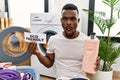 Young african man doing laundry holding eco friendly paper afraid and shocked with surprise and amazed expression, fear and