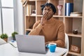 Young african man with dreadlocks working using computer laptop bored yawning tired covering mouth with hand Royalty Free Stock Photo