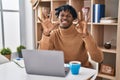 Young african man with dreadlocks working using computer laptop showing and pointing up with fingers number eight while smiling Royalty Free Stock Photo