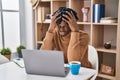 Young african man with dreadlocks working using computer laptop suffering from headache desperate and stressed because pain and Royalty Free Stock Photo