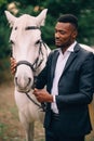 A young African man stroking a horse. Royalty Free Stock Photo