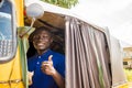 young african man driving a rickshaw taxi counting his money smiling giving a thumbs up