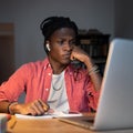 Young African man freelancer feeling tired of monotonous tasks, looking at laptop with upset face Royalty Free Stock Photo