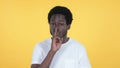Casual African Man Gesturing Silence, Finger on Lips, Yellow Background Royalty Free Stock Photo