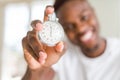 Young african man holding silver retro stopwatch counting time