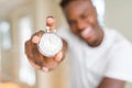 Young african man holding silver retro stopwatch counting time