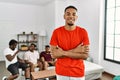 Young african man at home with friends sitting on the sofa at home happy face smiling with crossed arms looking at the camera Royalty Free Stock Photo