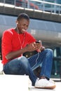 Young african man listening music on cell phone Royalty Free Stock Photo