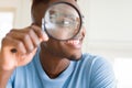 Young african man looking through magnifying glass Royalty Free Stock Photo