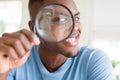 Young african man looking through magnifying glass Royalty Free Stock Photo