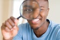 Young african man looking through magnifying glass Royalty Free Stock Photo