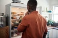 Young African man looking for something in his fridge Royalty Free Stock Photo