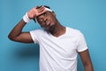 Young african man looking tired and frustrated, drying sweat off forehead Royalty Free Stock Photo