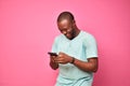 young african man looking very excited while using his cellphone Royalty Free Stock Photo