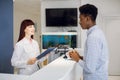 Young African man near reception desk in modern medical or dental clinic