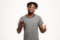 Young african man pointing fingers at camera over white background.