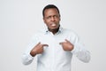 Young african man pointing at himself, making excuses or verbally defending, Royalty Free Stock Photo