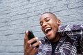 Young african man reading a funny text message on his phone Royalty Free Stock Photo