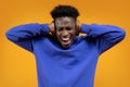 Young african man screaming, covering ears on yellow Royalty Free Stock Photo