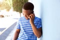 Young african man smiling and talking on mobile phone outside Royalty Free Stock Photo