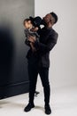 Young african man stands and holds on arms his baby daughter from interracial marriage