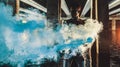 Young African man stands under bridge and holds colored blue smoke bomb Royalty Free Stock Photo