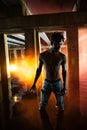 Young African man stands under bridge and holds colored red smoke bomb Royalty Free Stock Photo