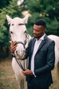 A young African man stroking a horse. Royalty Free Stock Photo