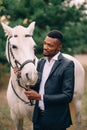 A young African man stroking a horse. Royalty Free Stock Photo