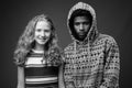 Young African man with teenage girl together against gray background Royalty Free Stock Photo