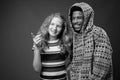 Young African man with teenage girl together against gray background Royalty Free Stock Photo