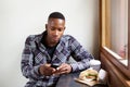 Young african man using mobile phone at a cafe Royalty Free Stock Photo