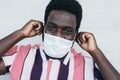 Young African man wearing face mask portrait - Afro American boy using protective facemask for preventing spread of corona virus