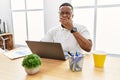 Young african man working at the office using computer laptop bored yawning tired covering mouth with hand Royalty Free Stock Photo