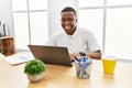 Young african man working at the office using computer laptop with a happy and cool smile on face Royalty Free Stock Photo