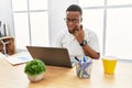 Young african man working at the office using computer laptop pointing to the eye watching you gesture, suspicious expression Royalty Free Stock Photo