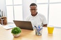 Young african man working at the office using computer laptop skeptic and nervous, frowning upset because of problem Royalty Free Stock Photo