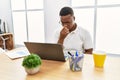 Young african man working at the office using computer laptop tired rubbing nose and eyes feeling fatigue and headache Royalty Free Stock Photo