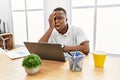 Young african man working at the office using computer laptop yawning tired covering half face, eye and mouth with hand Royalty Free Stock Photo